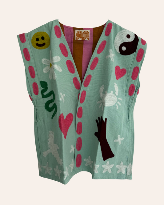 Mint green embroidered summer vest with pink, white, and green symbols including snake, smiley, heart, yin-yang, and bird front