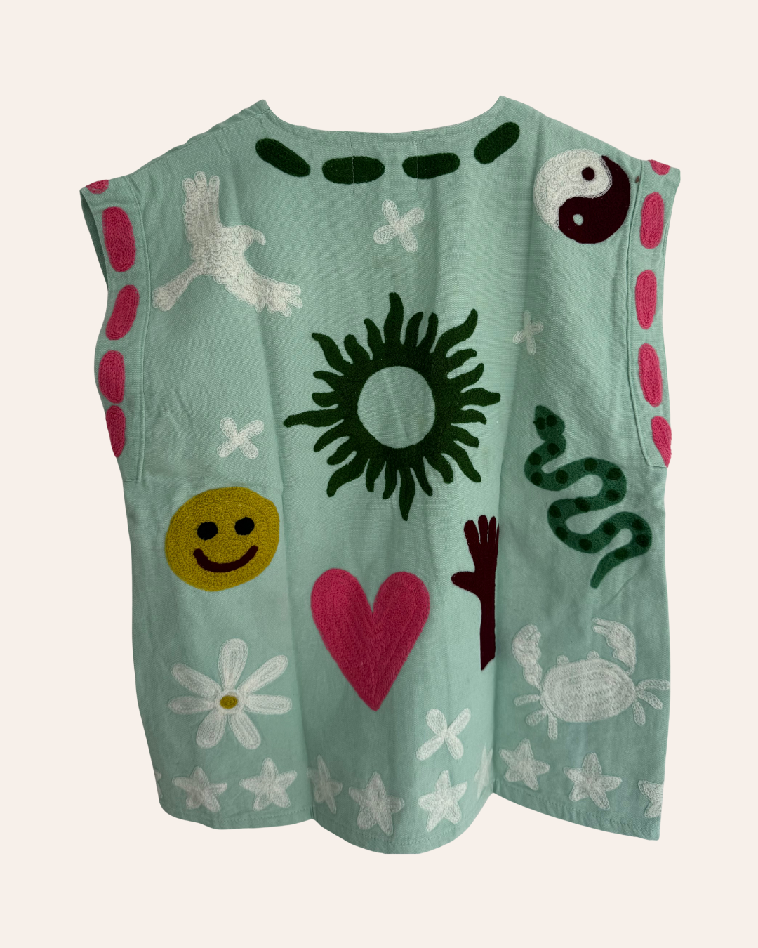 Embroidered summer vest with pink, white, and green symbols including snake, smiley, heart, yin-yang, and bird back
