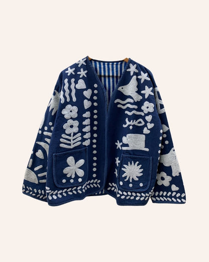 Front view of navy blue embroidered jacket with floral, bird, and Arabic motifs in white thread, featuring patch pockets and open front design.