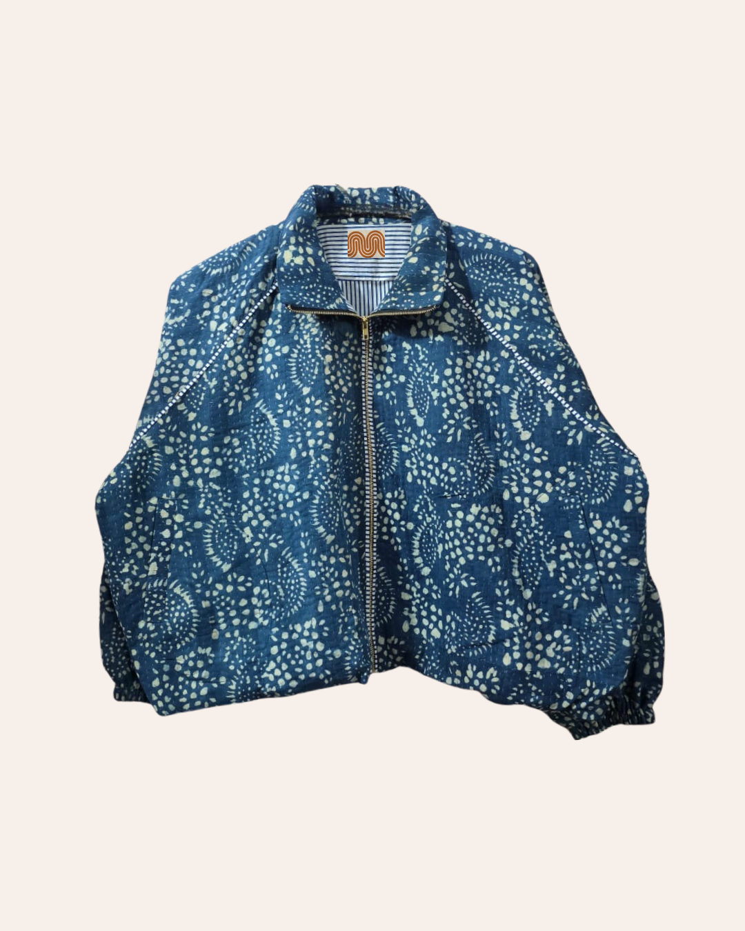 Blue block print bomber jacket with white floral patterns