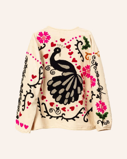 Cream cotton jacket hand-embroidered with black peacock, pink florals, red hearts, and swirling folk-style vines.
