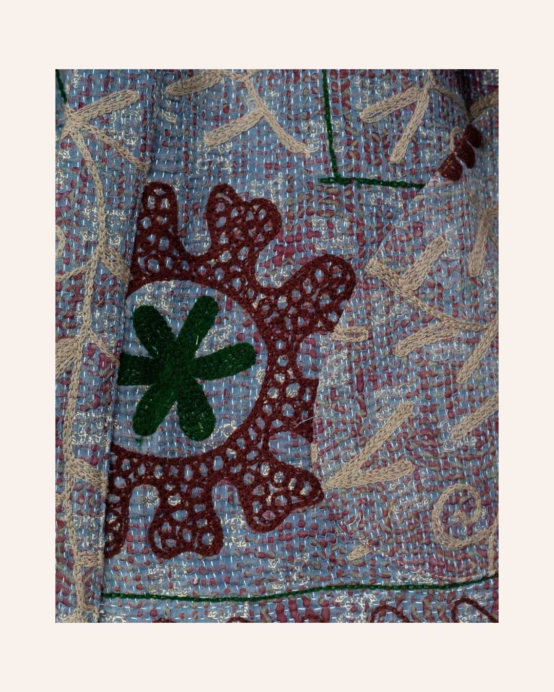 A richly embroidered vintage Suzani kimono featuring detailed floral motifs in earthy tones on a textured base.