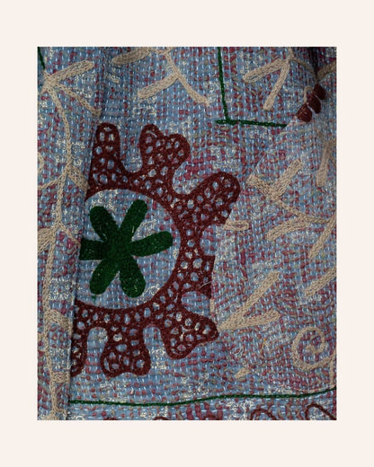A richly embroidered vintage Suzani kimono featuring detailed floral motifs in earthy tones on a textured base.